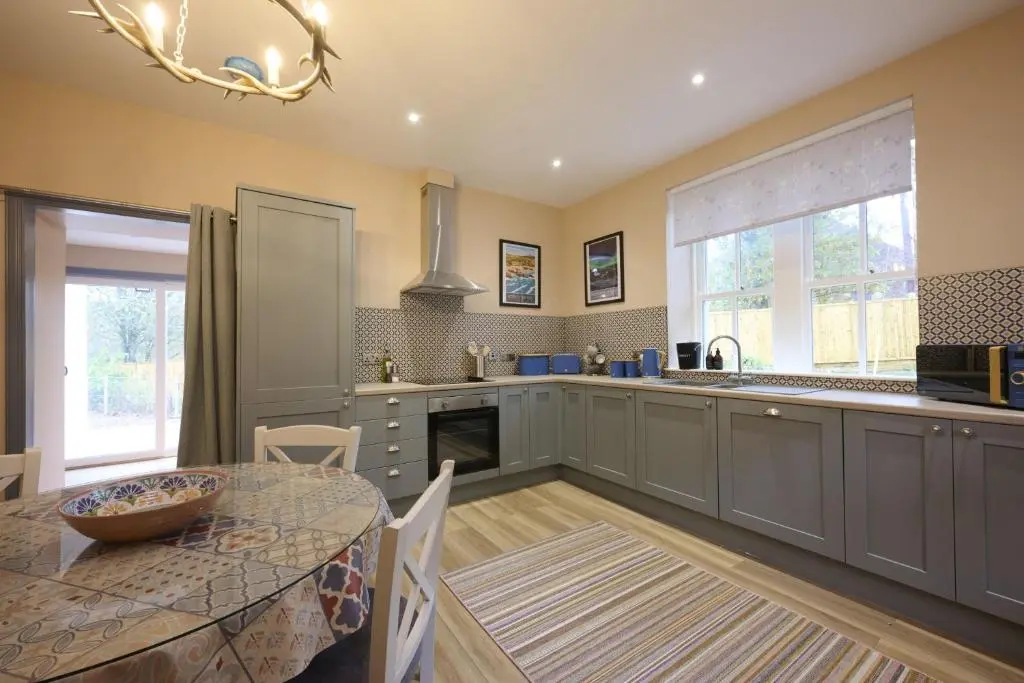 a kitchen with a table and a dining room at Church Cottage in Inverness