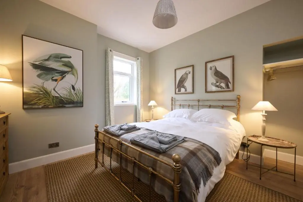 a bedroom with a bed and two lamps and a window at Church Cottage in Inverness