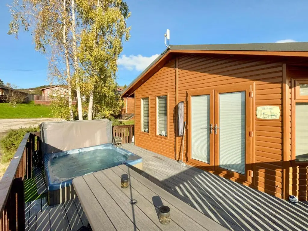 a hot tub on a deck next to a tiny house at Haven Lodge - Uk50792 in Banchory