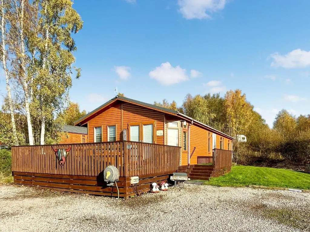 a small wooden cabin with a porch on a gravel lot at Haven Lodge - Uk50792 in Banchory