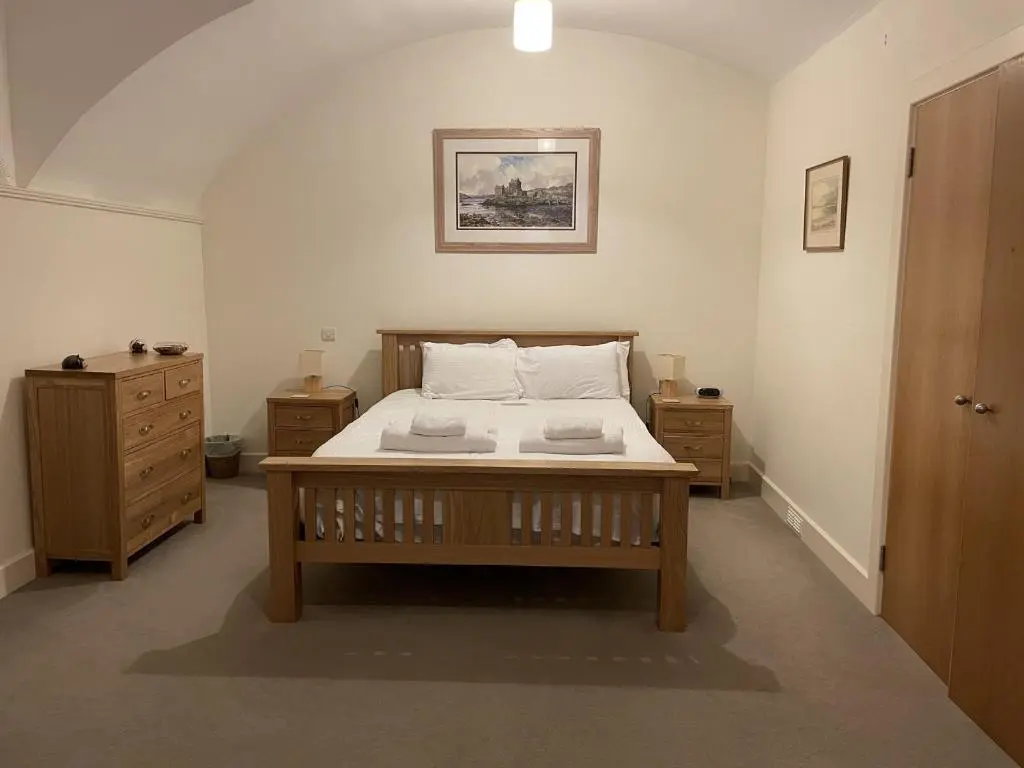 a bedroom with a bed with two nightstands at Moat House 1 in Fort Augustus