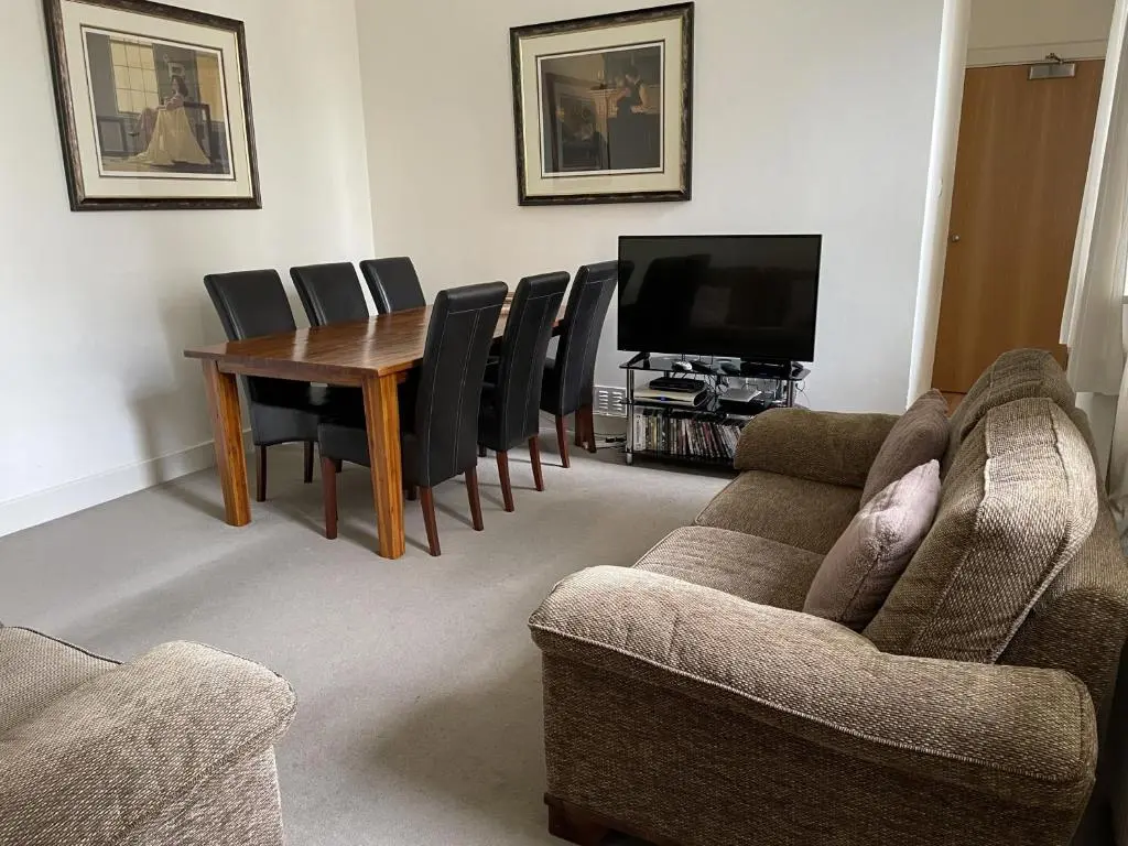 a living room with a table and chairs and a television at Moat House 1 in Fort Augustus