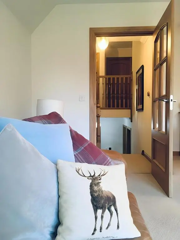 a painting of a deer on a pillow on a bed at Carn Mhor Lodge in Aviemore