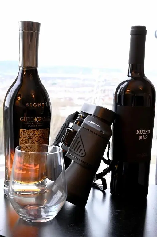 a camera next to a bottle of wine and a glass at High-Ness View in Inverness