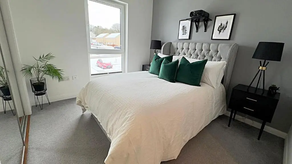a bedroom with a large bed with green pillows at High-Ness View in Inverness