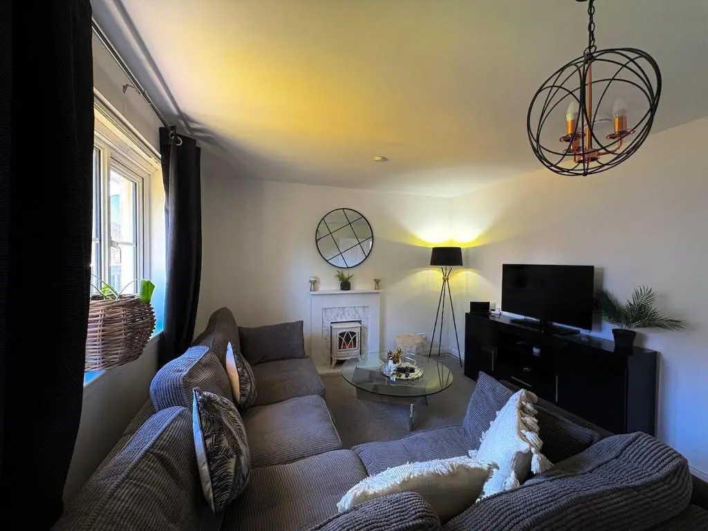 a living room with a couch and a tv at Peaceful Abode in Inshes