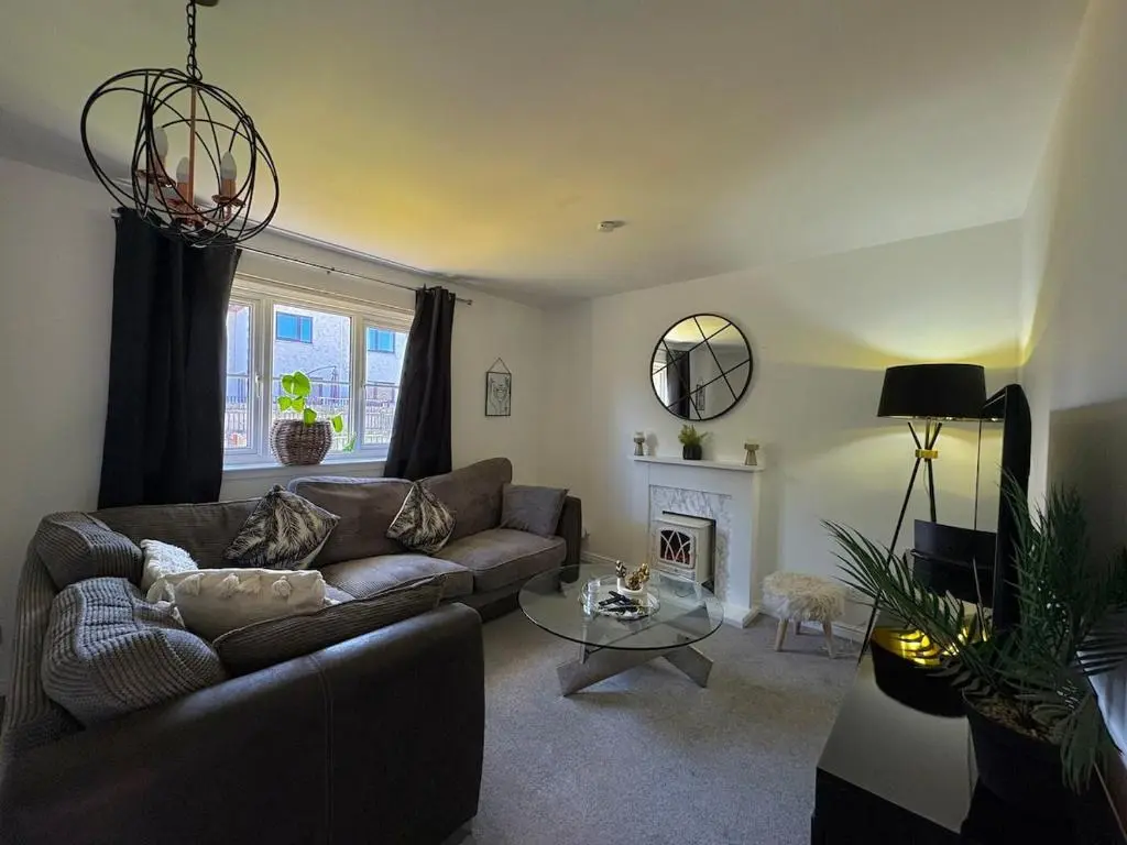 a living room with a couch and a fireplace at Peaceful Abode in Inshes