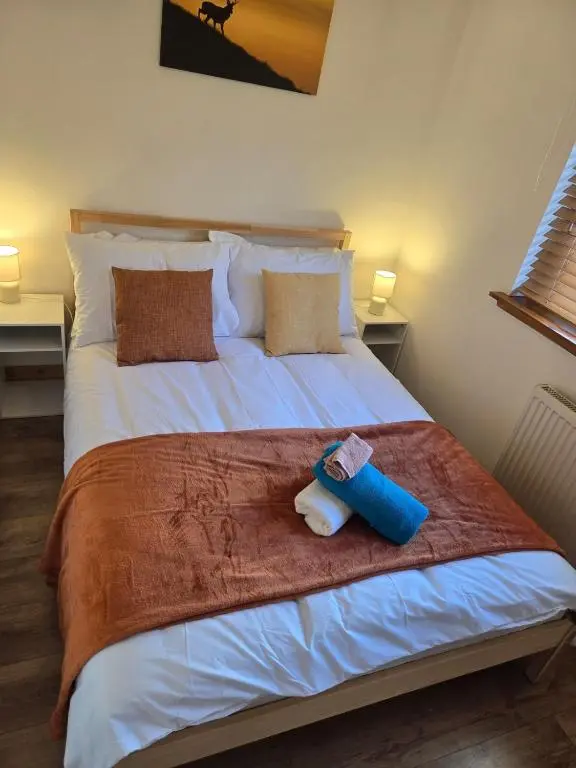 a bed with a stuffed animal sitting on top of it at The Highland Nook in South Kessock