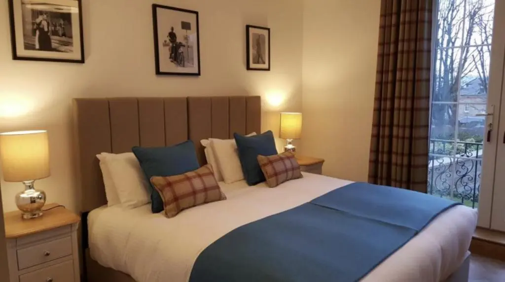 a bedroom with a large bed with pillows and a window at Royal Gardens Apartment 2 in Dornoch