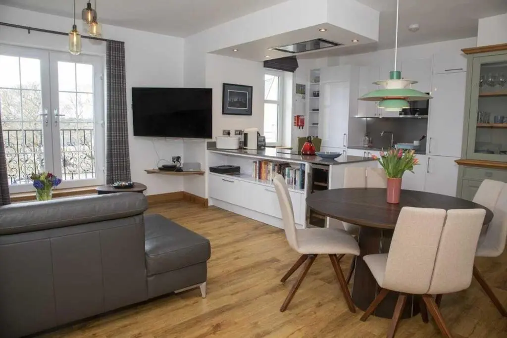 a kitchen and dining room with a table and chairs at Royal Gardens Apartment 11 in Dornoch