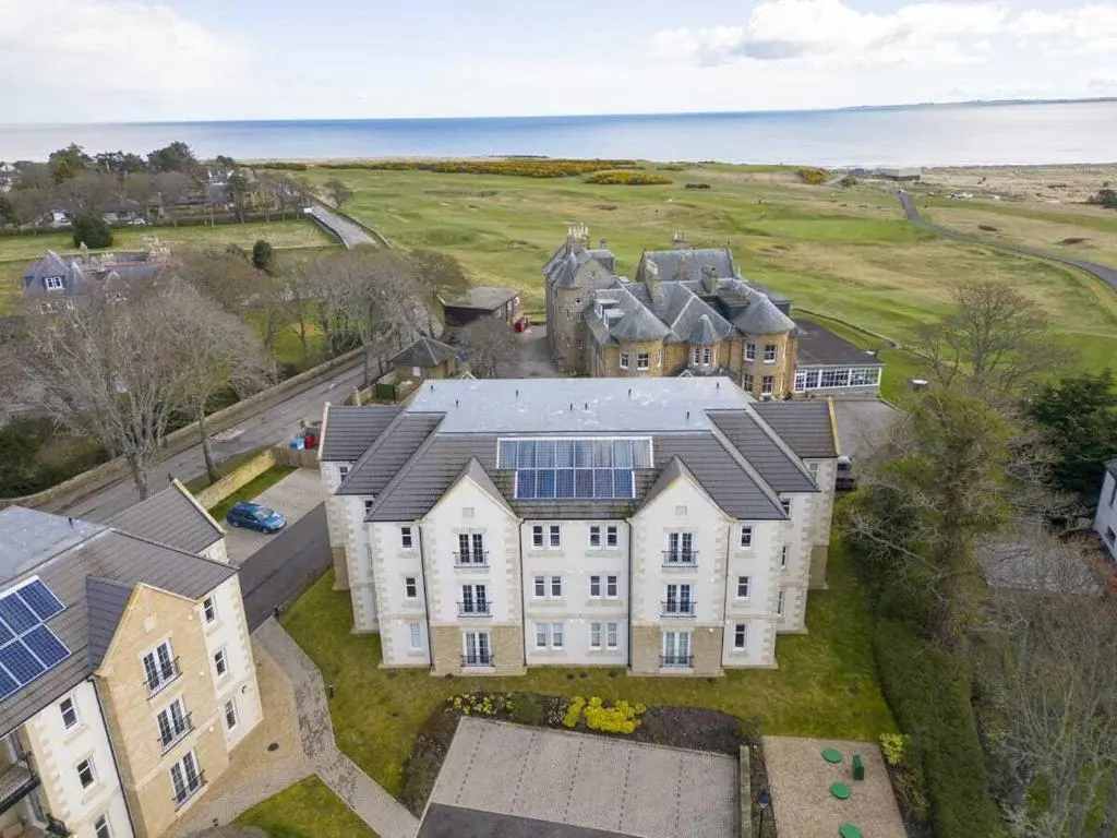 an aerial view of a large house with solar panels at Royal Gardens Apartment 11 in Dornoch