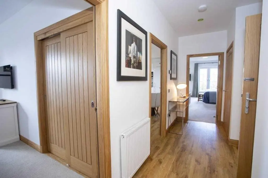 a hallway with a door and a room with a desk at Royal Gardens Apartment 11 in Dornoch