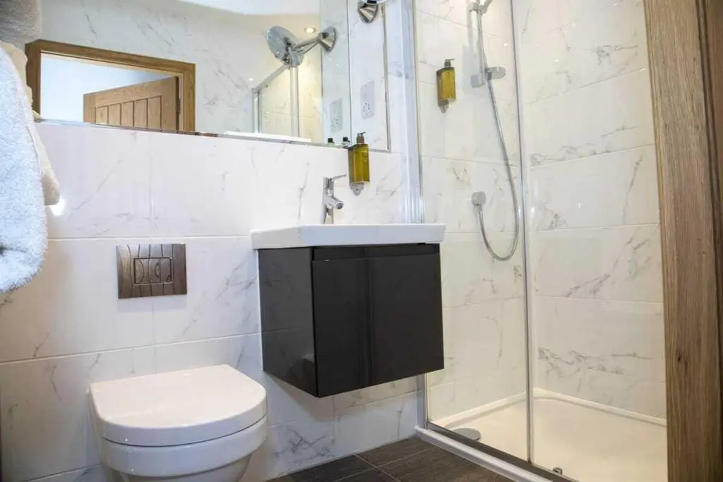 a bathroom with a shower and a toilet and a sink at Royal Gardens Apartment 11 in Dornoch
