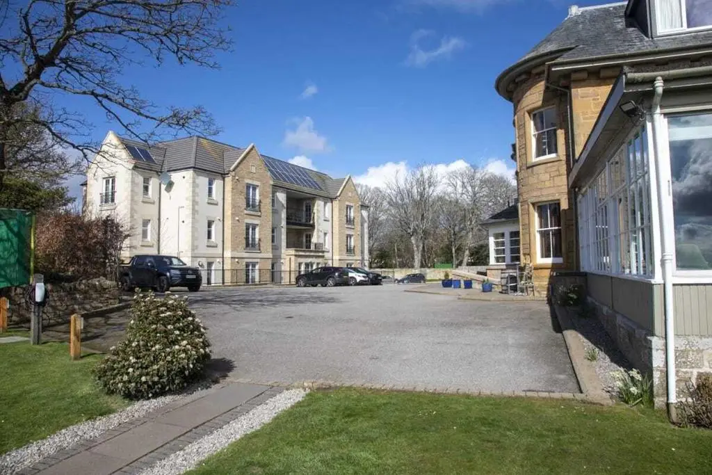 a parking lot in front of a large house at Royal Gardens Apartment 10 in Dornoch