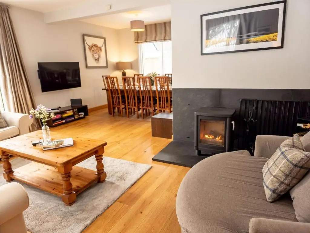 a living room with a couch and a fireplace at Loramore in Aviemore