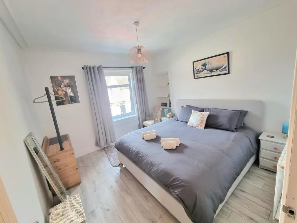 a bedroom with a large bed and a window at 2 bedroom flat- 5 minutes walk from city centre in Inverness