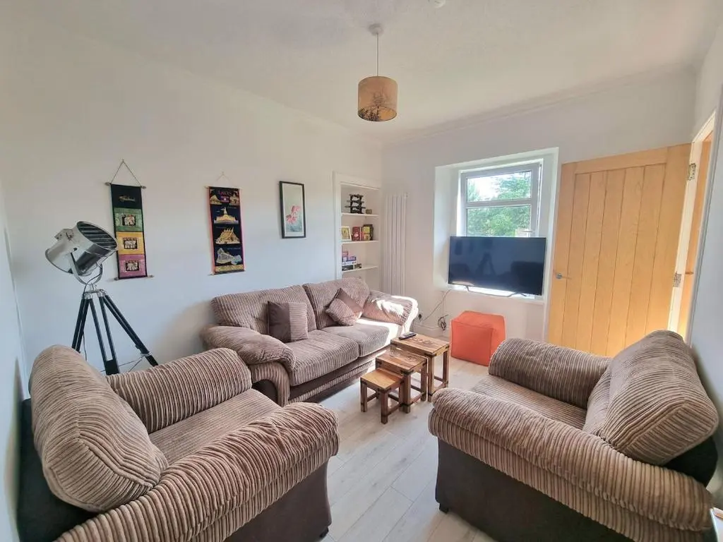 a living room with two couches and a television at 2 bedroom flat- 5 minutes walk from city centre in Inverness