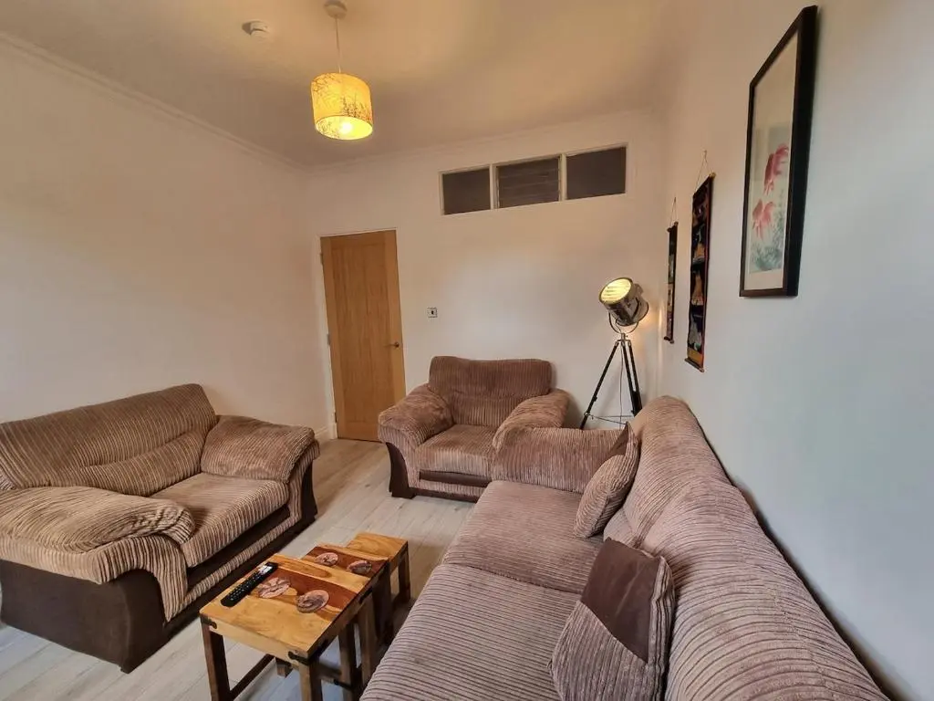 a living room with two couches and a table at 2 bedroom flat- 5 minutes walk from city centre in Inverness