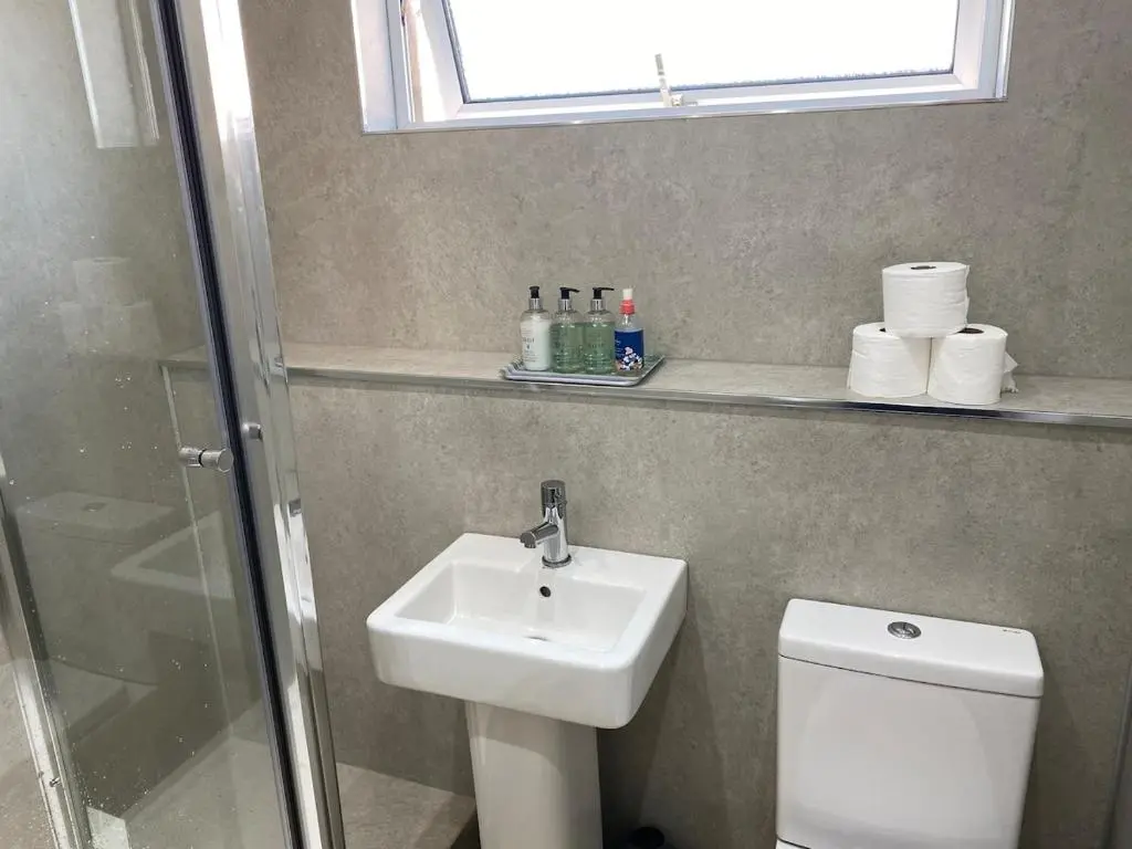 a bathroom with a sink and a toilet and a window at Highland haven, free parking on driveway, near Raigmore Hospital in Inshes
