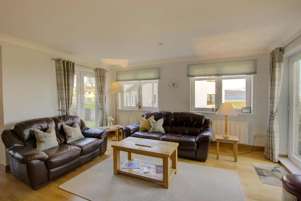a living room with two leather couches and a table at No8 The Links Apartment, Brora in Brora
