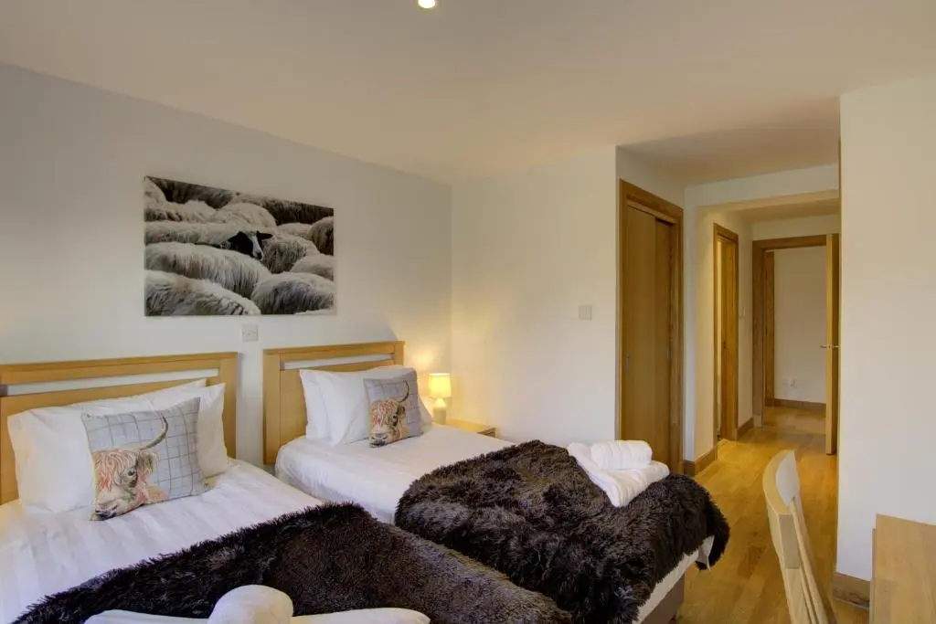 two beds sitting next to each other in a room at No8 The Links Apartment, Brora in Brora