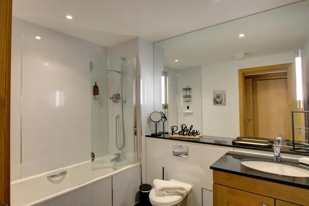 a bathroom with a sink and a shower and a toilet at No8 The Links Apartment, Brora in Brora