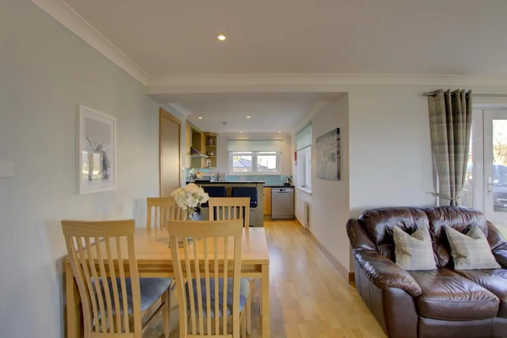 a living room and kitchen with a couch and a table at No8 The Links Apartment, Brora in Brora