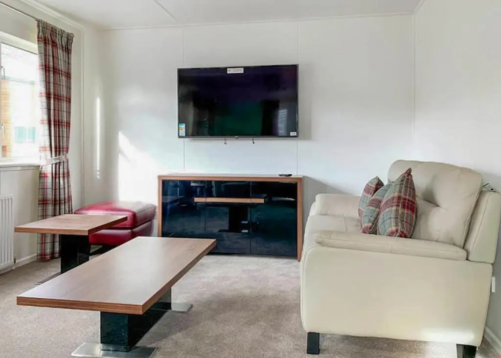 a living room with a couch and a table and a tv at Calvine Holiday Park in Pitlochry
