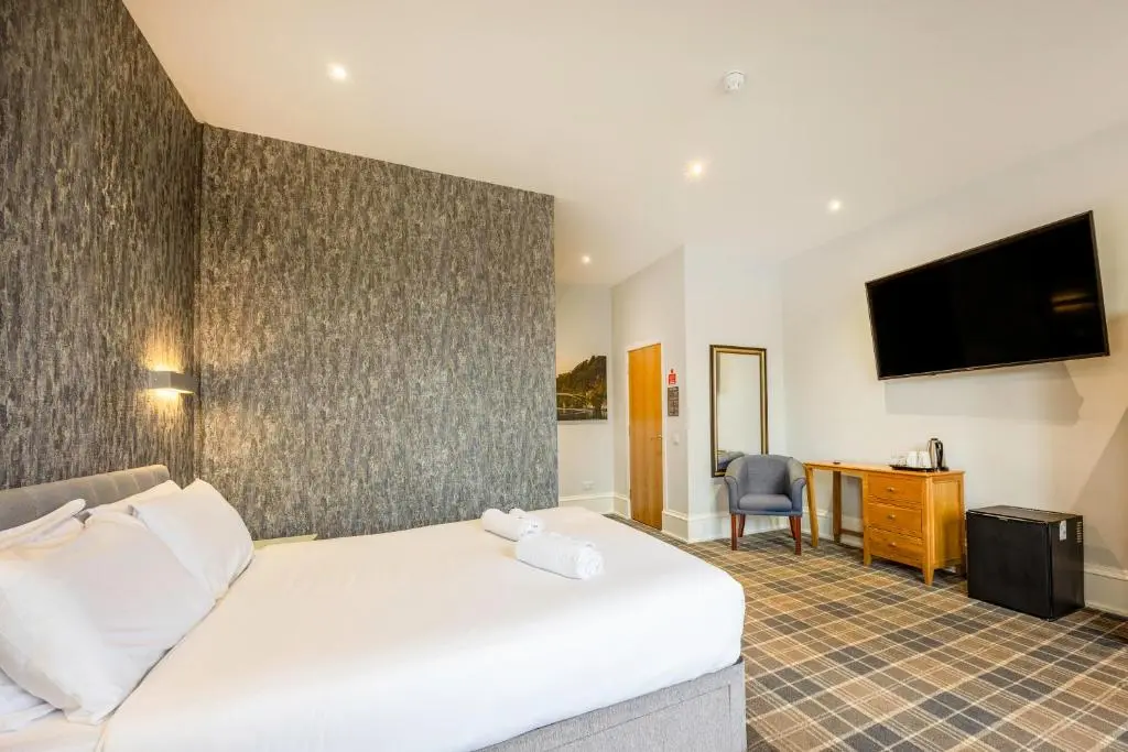 a hotel room with a bed and a television at Crown Hotel & Bar in Inverness
