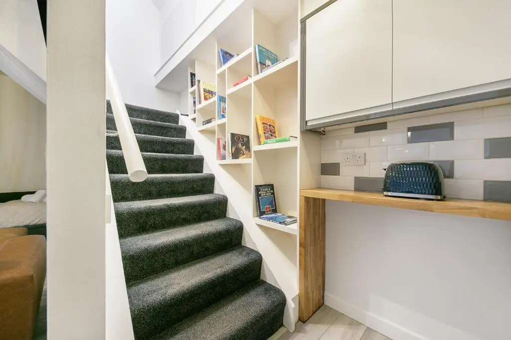 a staircase with green carpeting in a small room at Rooemah Lodge - Grampian Lettings in Caskieben
