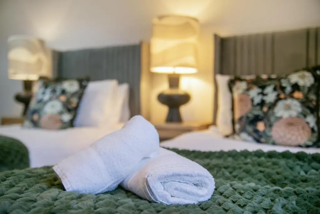 a towel laying on a bed in a hotel room at Rooemah Lodge - Grampian Lettings in Caskieben