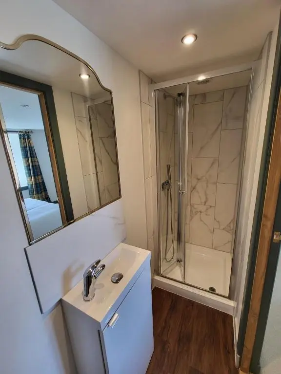 a bathroom with a sink and a shower at Gardeners Cottage
