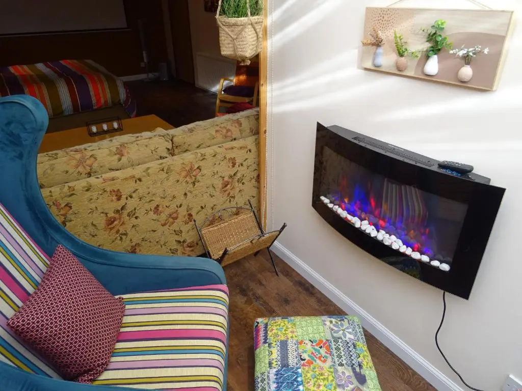 a living room with a tv on a wall at 'Le Studio' in Inverness