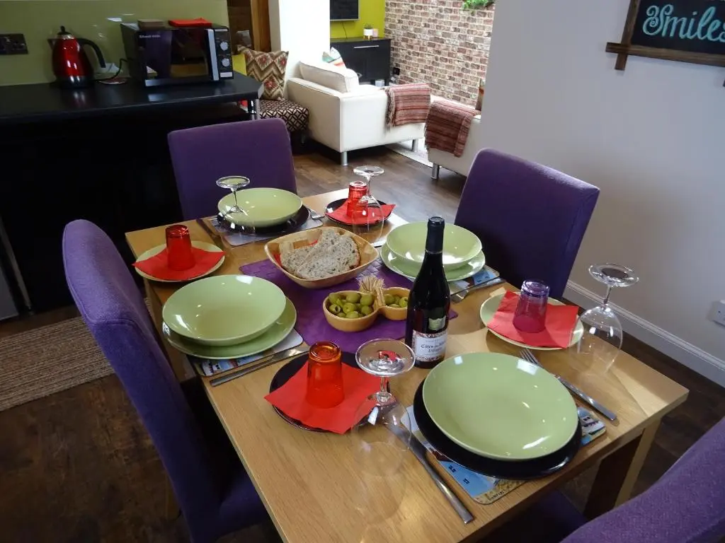 a wooden table with plates and a bottle of wine at 'Le Studio' in Inverness