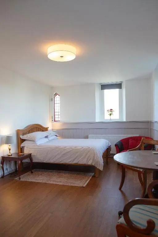 a bedroom with a large bed and a table at Old Church in Inverness