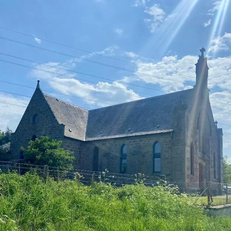 an old brick church with the sun shining on it at Old Church in Inverness