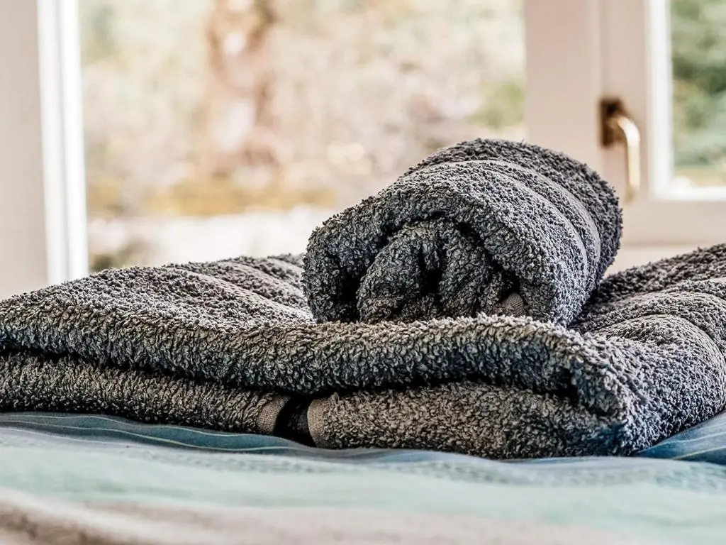 a pile of towels sitting on top of a bed at Holiday Home Corrimony View by Interhome in Drumnadrochit