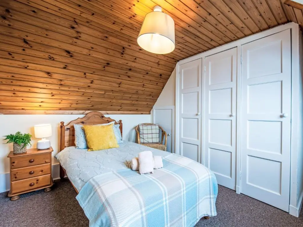 a bedroom with a bed and a wooden ceiling at Holiday Home Bunloit Farmhouse by Interhome in Drumnadrochit