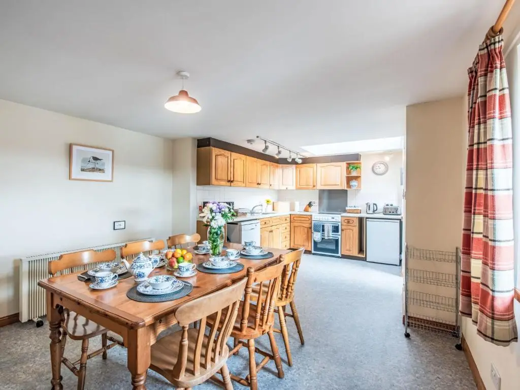 a kitchen and dining room with a wooden table and chairs at Holiday Home Wester Bunloit by Interhome in Drumnadrochit