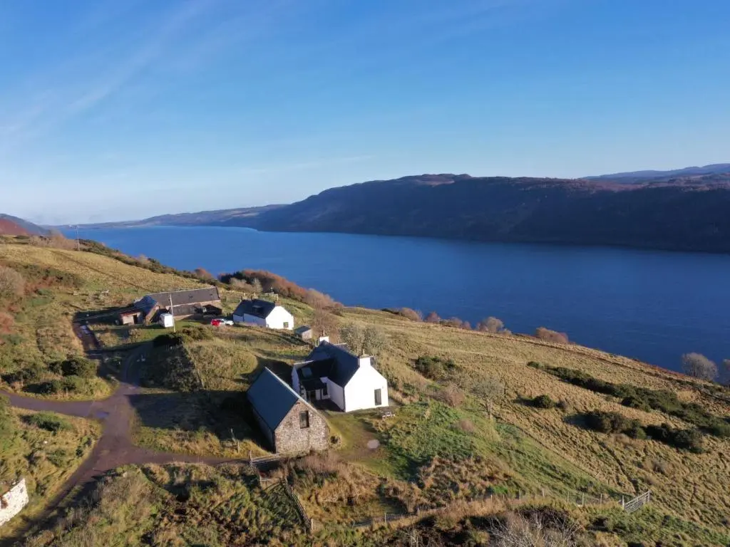 an aerial view of a farm on a hill next to a lake at Holiday Home Wester Bunloit by Interhome in Drumnadrochit
