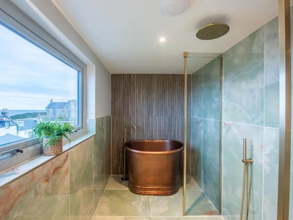 a bathroom with a copper tub and a window at Holiday Home Cooriedoon by Interhome in Hopeman