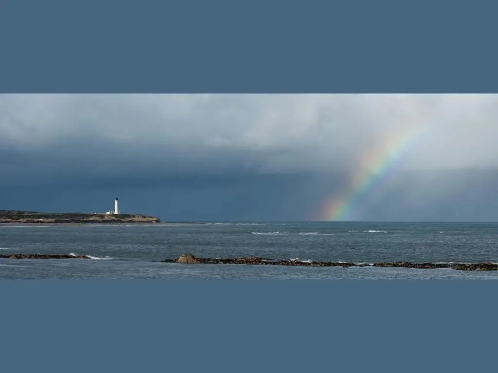 a rainbow over the ocean with a body of water at Apartment Pitgaveny Apartment by Interhome in Lossiemouth