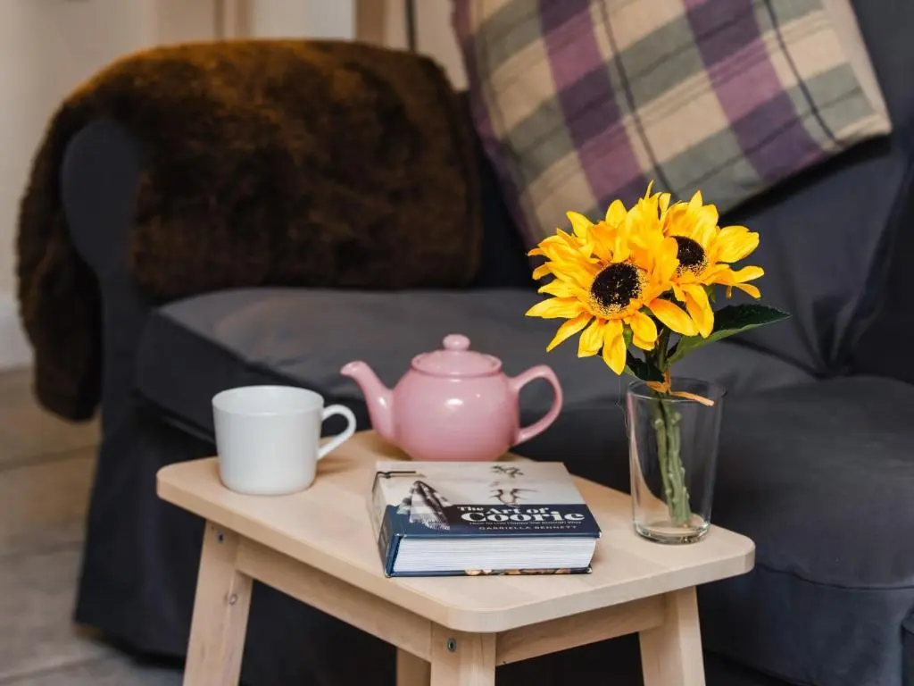 a table with a vase with a sunflower on it at Holiday Home Wayside Bothy by Interhome in Drumnadrochit