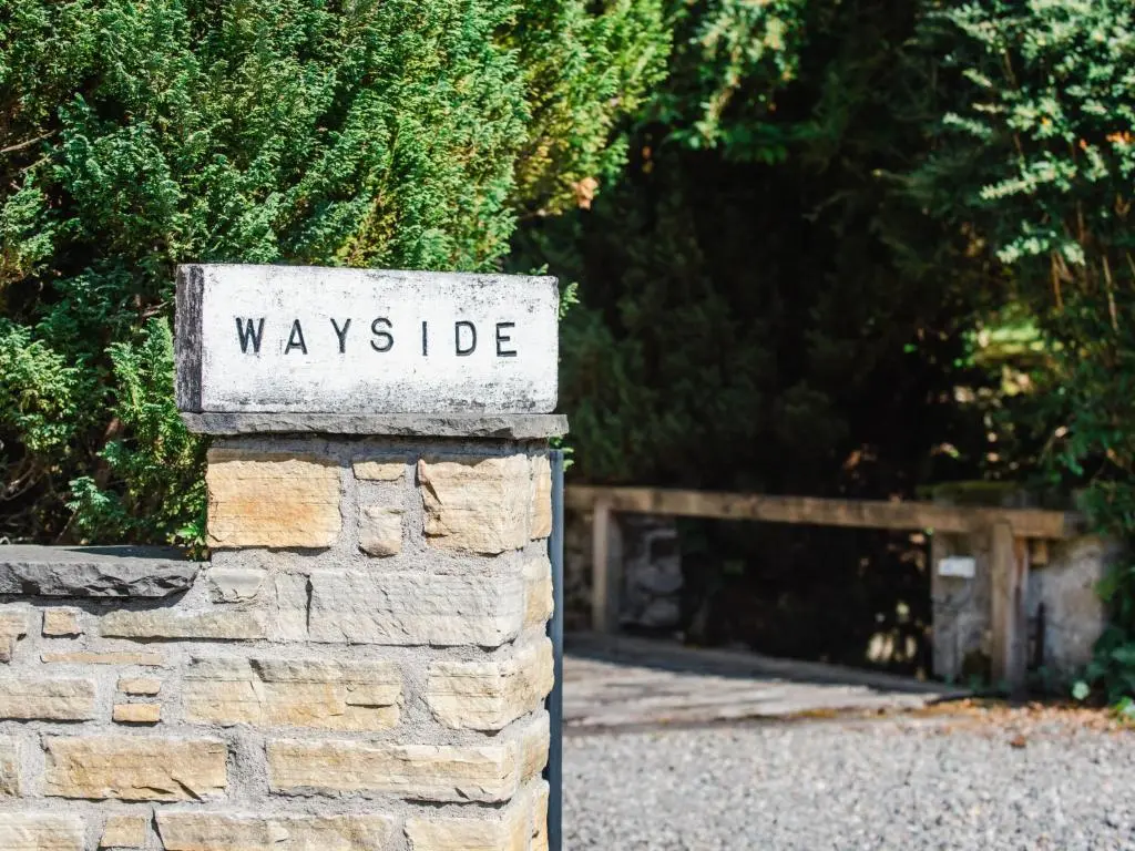 a sign that says wayside on a stone wall at Holiday Home Wayside Bothy by Interhome in Drumnadrochit