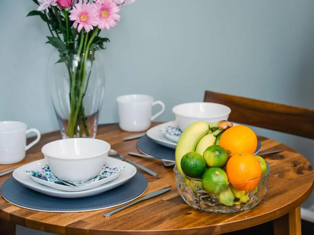 a wooden table with a bowl of fruit on it at Holiday Home Wayside Bothy by Interhome in Drumnadrochit