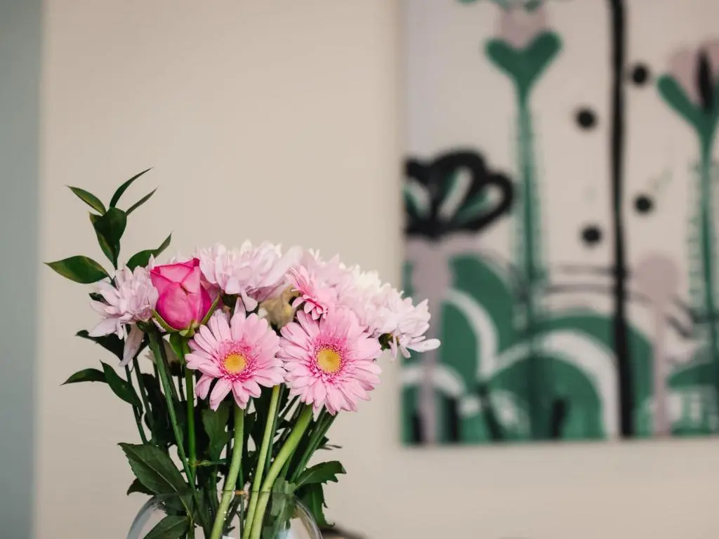 a vase filled with pink flowers on a table at Holiday Home Wayside Bothy by Interhome in Drumnadrochit