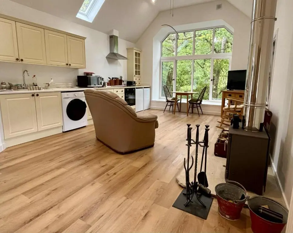 a living room with a kitchen and a dining room at Ardachy Riverside Accessible One bedroom Holiday let in Fort Augustus