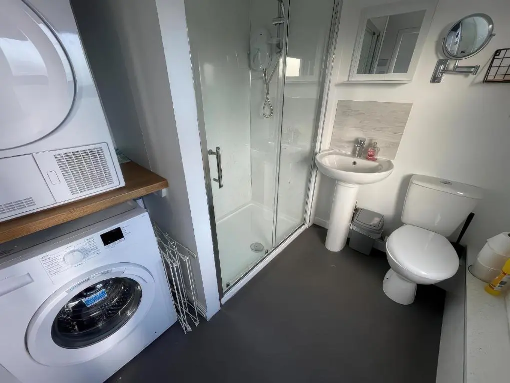 a small bathroom with a washing machine and a sink at Home in Forres, Moray in Forres