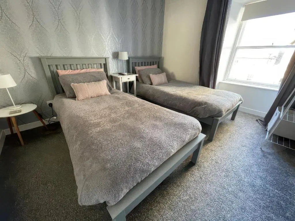 a bedroom with two beds and a window at Home in Forres, Moray in Forres