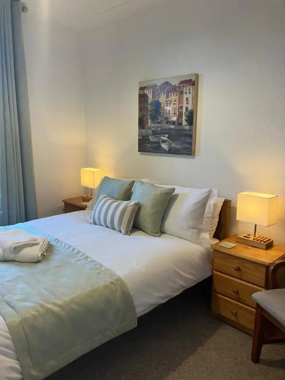 a bedroom with a large white bed and a nightstand at Toll House in Wick